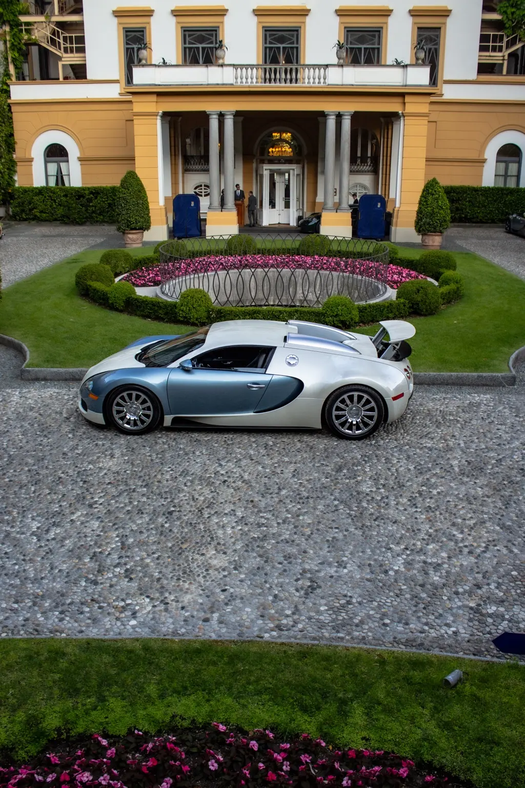 Bugatti Veyron vista dall’alto davanti all’ingresso simmetrico della villa