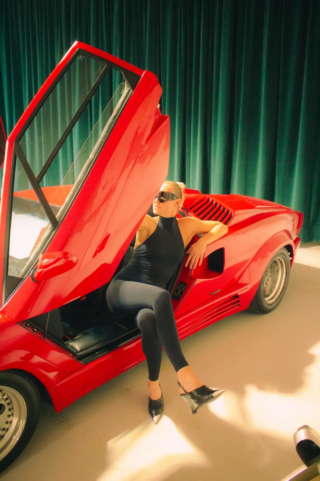 Alyona seated beside the Countach open door