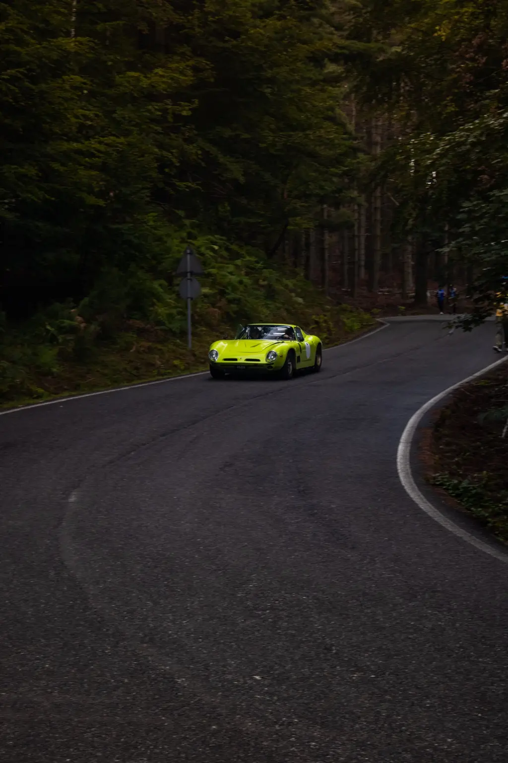 Supercar verde affronta una curva nel bosco