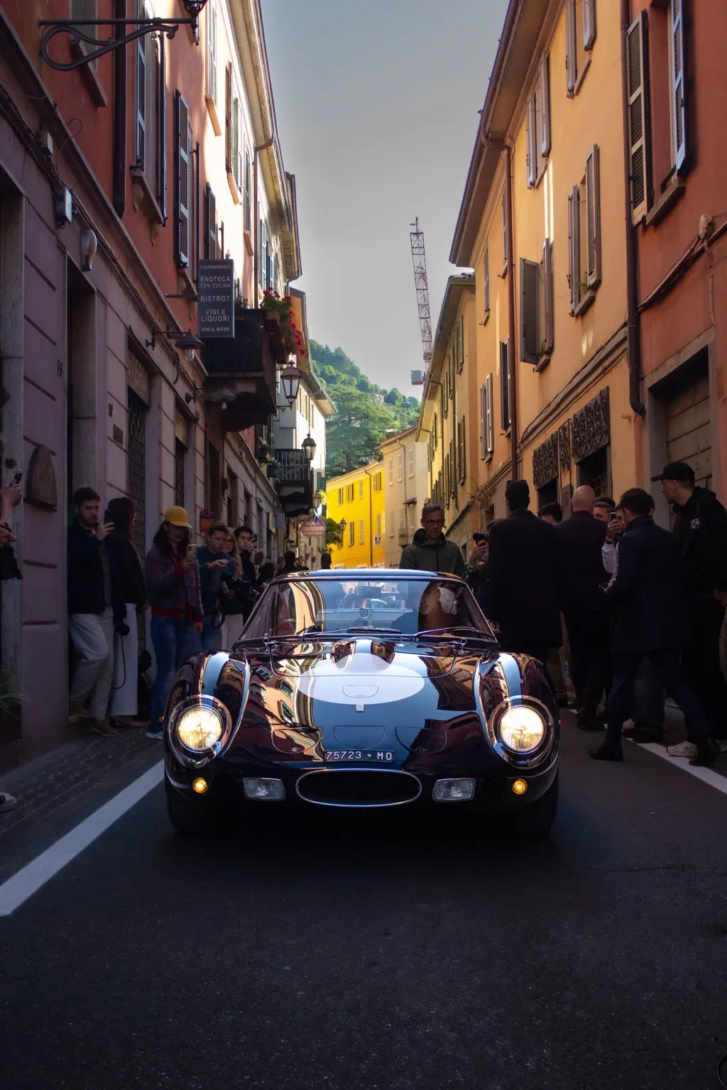 Automobile classica attraversa una strada tra il pubblico