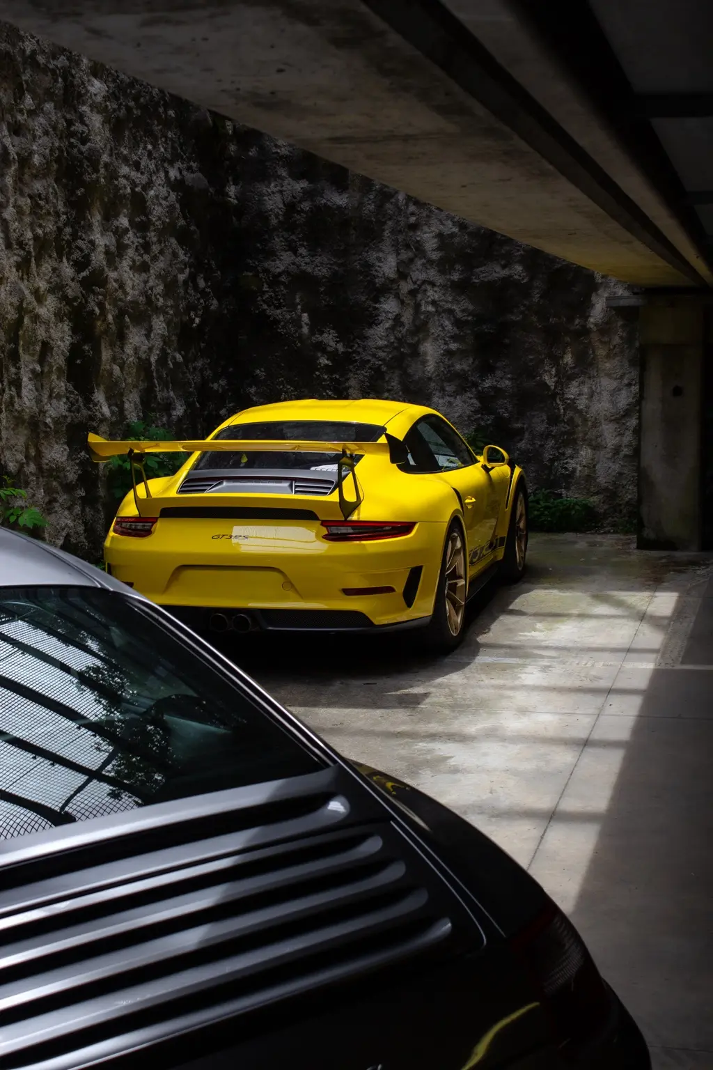 Porsche gialla vista tra architetture in cemento