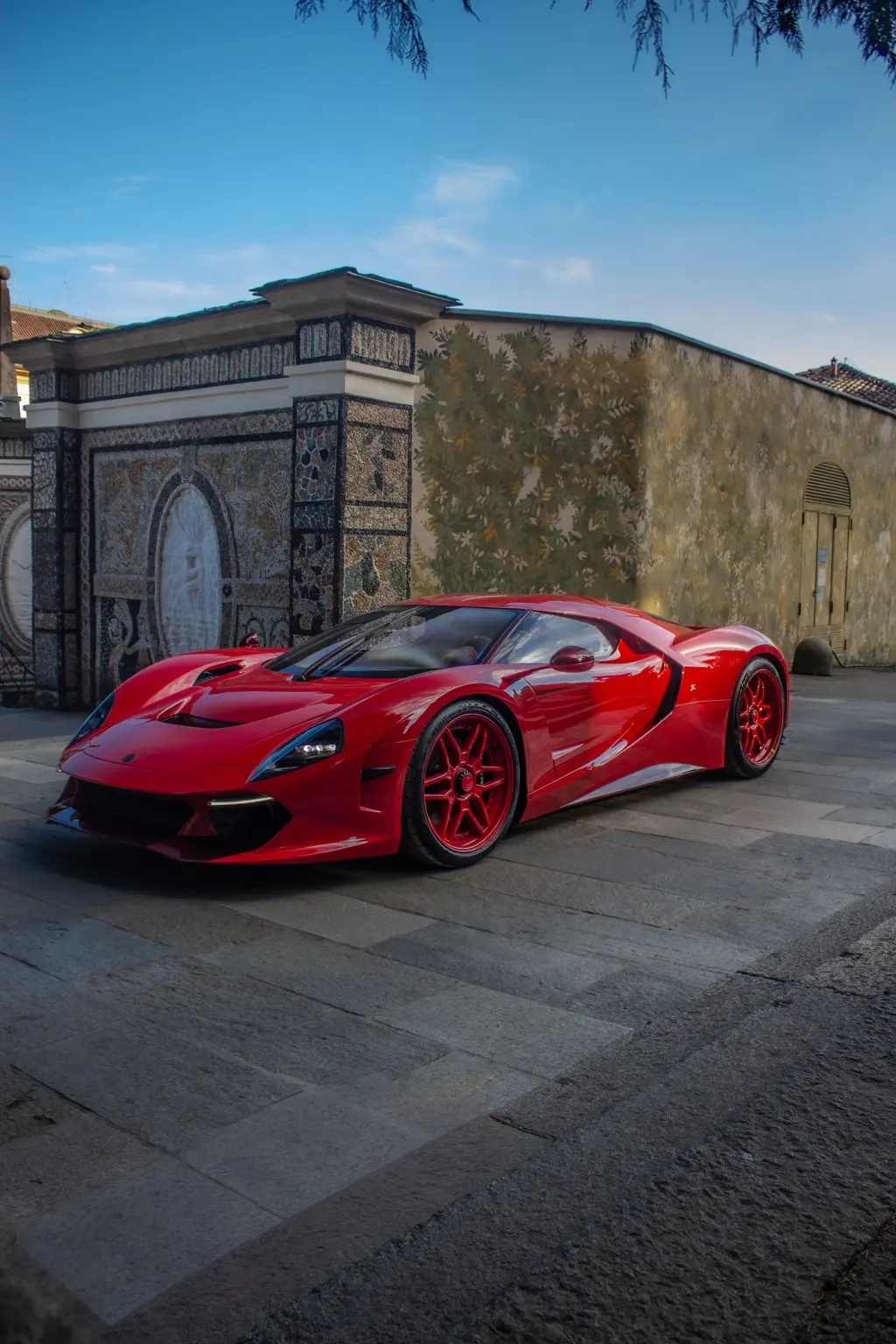 Automobile sportiva rossa davanti a un edificio decorato