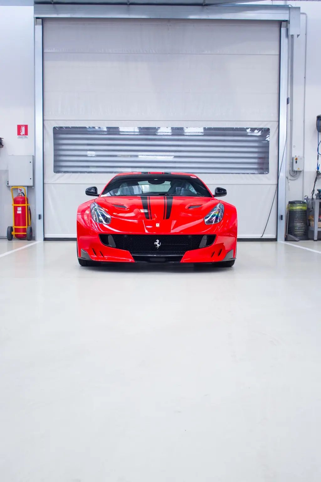 Ferrari rossa fotografata frontalmente in officina
