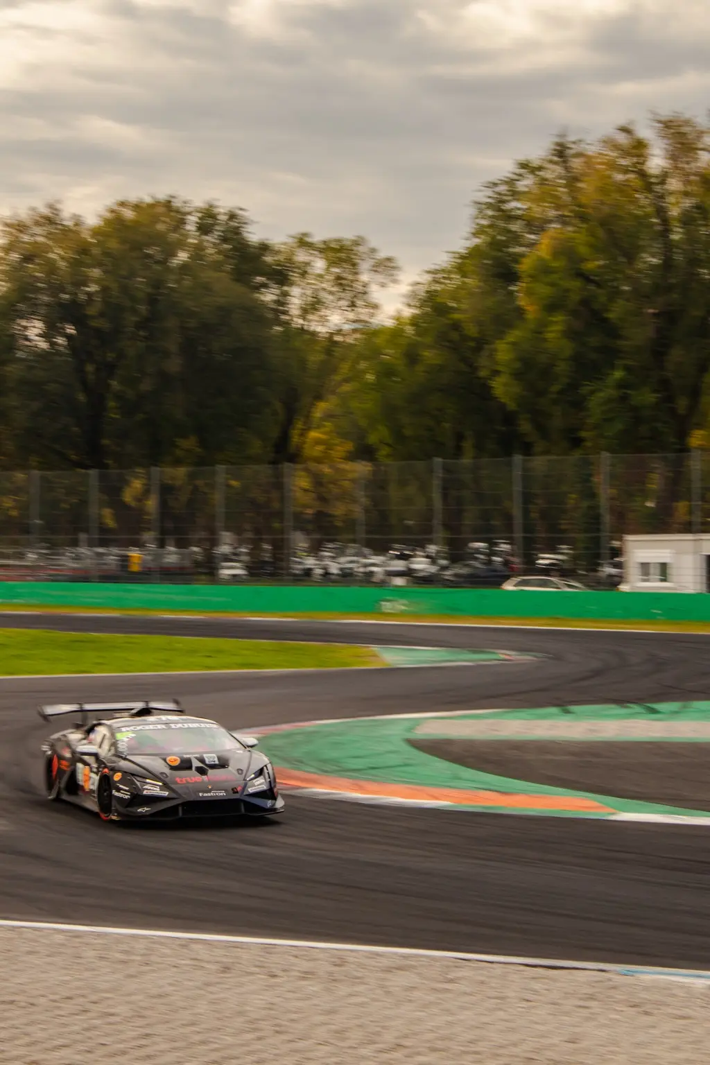 Dark Lamborghini race car turning into a corner at Monza